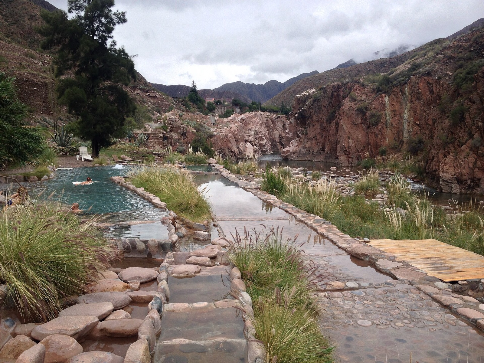 Piscinas termais em terraços em Cacheuta com as paredes do cânion atrás