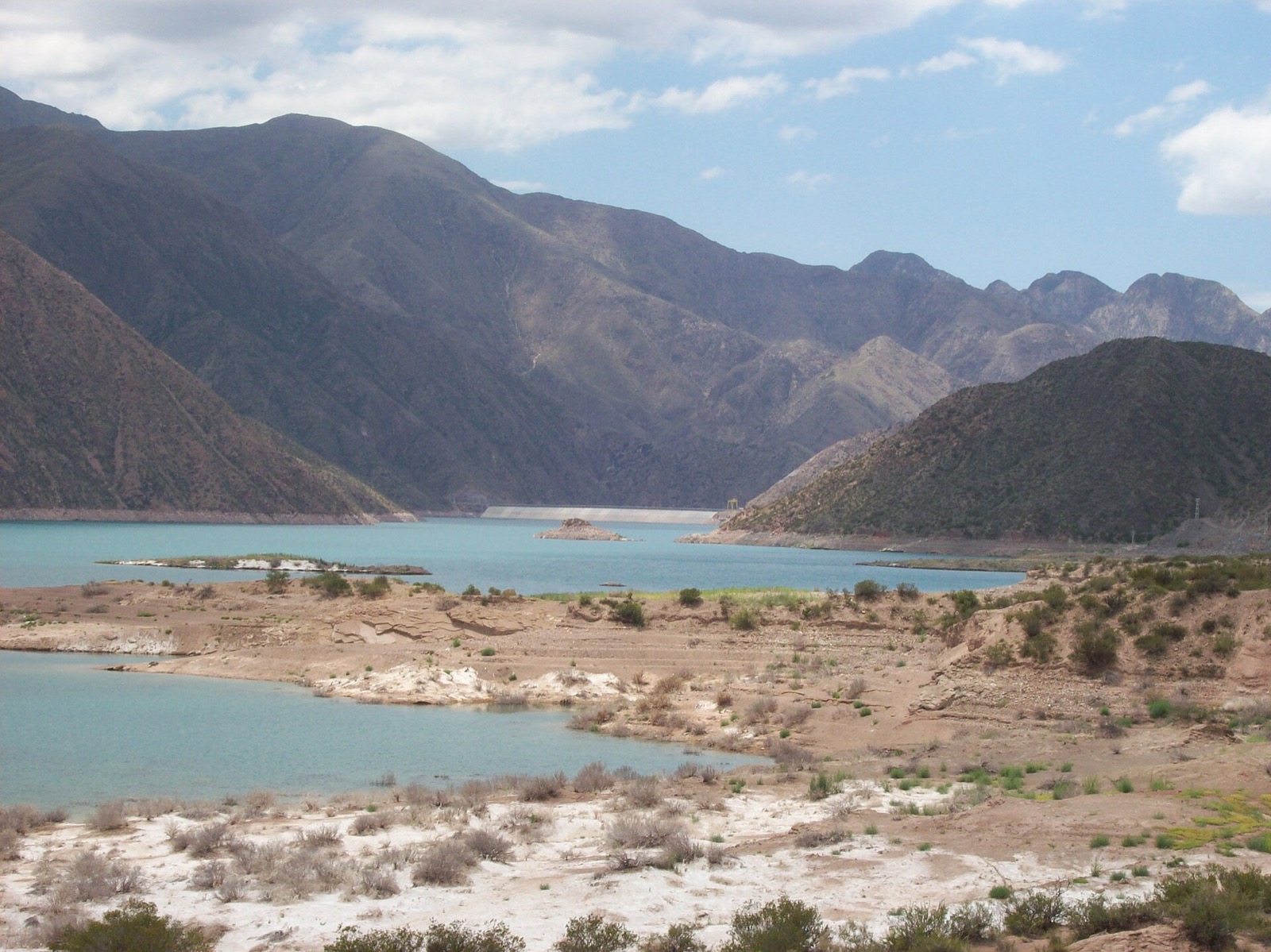 A represa turquesa de Potrerillos com o paredão da barragem